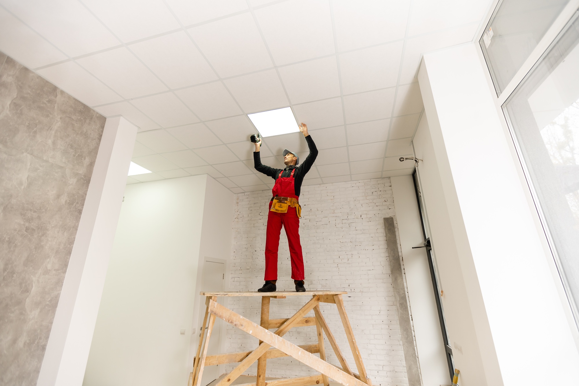 Builder replacing ceiling panel, working, ceiling armstrong