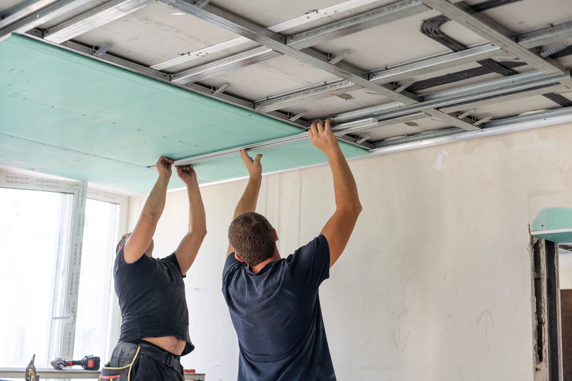 Construction worker ceiling work installation